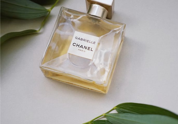 Clear glass bottle with a gold cap containing Gabrielle Essence Eau De Parfum by Chanel, displayed against a clean background.